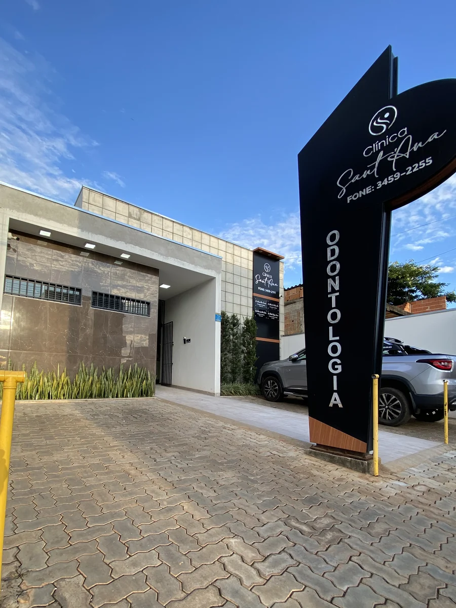 Fachada da Clínica Sant'Ana, com o totem na entrada e estacionamento na porta